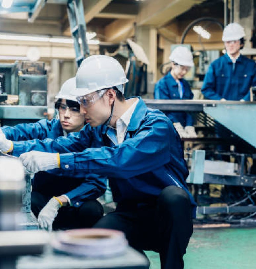 Workers servicing machinery at the factory